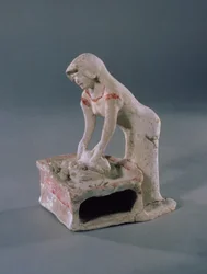 Mulher amassando pão em cima de uma laje quadrada, grega, de Aulis, c.500-475 aC (argila com pasta branca e pigmento vermelho)