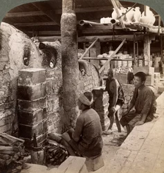 Trabalhadores assistindo fornos cheios de porcelana Awata, obras de Kinkosan, Kyoto, Japão, 1904