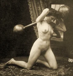 Nu feminino a exercitar-se com uma barra de pesos esféricos, c. 1900