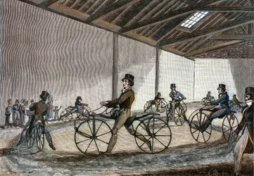 Vista interna do manège para o cavalo Hobby. Homem a conduzir bicicletas (bicicletas sem pedal, inventadas pelo Barão Karl Drais