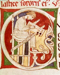 Carta C enfeitada com um monge escrevendo sobre uma mesa. Miniatura de "Vitae sanctorum" (Vida dos Santos) Coimbre do século XII, biblioteca universitária