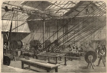 Telegrafia: fabrico de cabos transatlânticos. Máquinas que revestem o cabo gutta percha na fábrica Glass, Elliot and Company em Wharf Road em Londres, Inglaterra. Gravação em "The Illustrated London News" de 14 de março