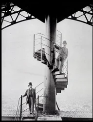 Gustave Eiffel e seu genro Adolphe Salles na escadaria da Torre Eiffel, Paris