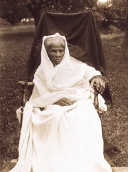 Harriet Tubman, retrato de corpo inteiro, sentado na cadeira, de frente para a frente, provavelmente em sua casa em Auburn, Nova York