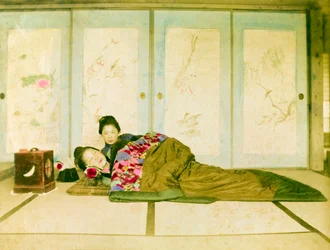 Reclinadas num futon. Duas mulheres japonesas reclinam-se num futon tradicional colocado no chão. Japão, cerca de 1910. Japão, Ásia Oriental, Ásia. ©Cultural Heritage Images/UIG/Leemage