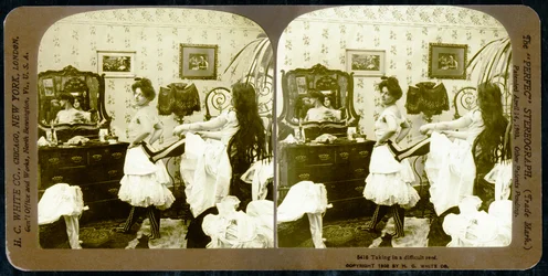 Cartão estereoscópico representando uma mulher sendo atada em um espartilho, c.1900 (foto sépia) (ver também 473244)