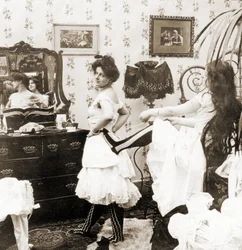 Cartão estereoscópico representando uma mulher sendo atada em um espartilho, c.1900 (foto sépia) (ver também 473243)