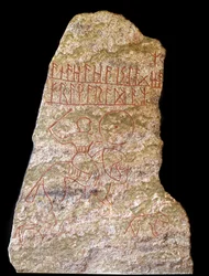 Uma estela com inscrições rúnicas representando um cavaleiro Viking com um cão (pedra)