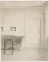 Interior com sofá e mesa pequena, t.h. uma porta