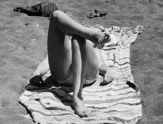 Pernas femininas numa praia, c.1960 (fotografia a preto e branco)