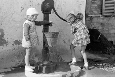 Meninas a encher um balde de água, 9 de maio de 1939 (fotografia a preto e branco)