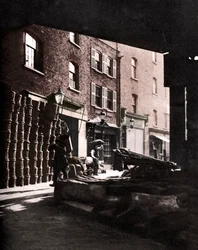 Cestas de frutas empilhadas contra casas no Borough Market, Londres, 1926-1927