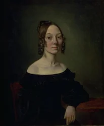 Retrato de uma menina de vestido preto sentada à mesa