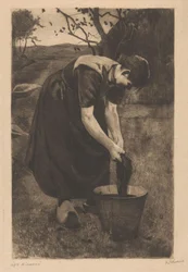 A mulher do agricultor lava os têxteis num balde