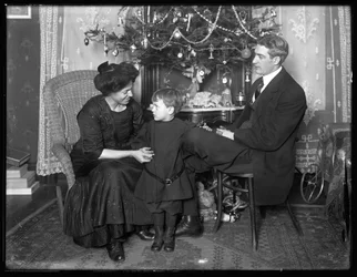 Dan Seymour e família em pose informal, sentado debaixo de uma árvore de Natal, Natal de 1912