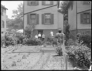 Família posa junto à sua horta no quintal, Inwood, Nova Iorque, c. 1910