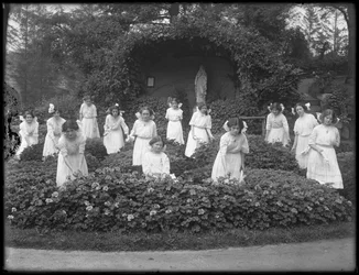Aula de formatura das meninas do asilo órfão católico romano no jardim de flores, em frente à gruta da Virgem Maria, 1912 foto bw
