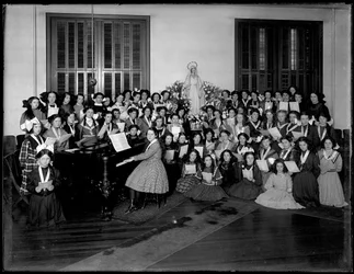 Grupo, retrato, de, um, meninas, coro, classe, juntado, ao redor, um, piano, segurando, partitura, provavelmente, em, a, católico roman, órdã, asilo, em, kingsbridge, bronx, c.1911