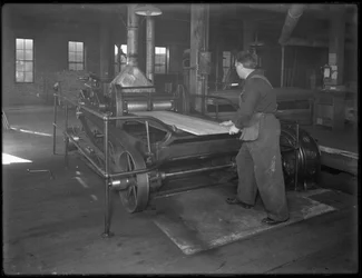Tábua de madeira destinada ao uso na fabricação de caixões por meio de uma plaina de superfície dupla, Oneida, Nova York, 3 de abril de 1916