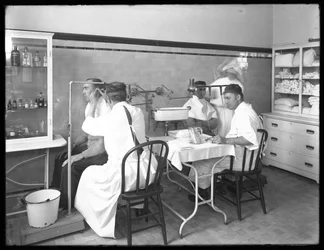 Dois pacientes sendo examinados na sala de exames do hospital principal, Hospital Seton, Spuyten Duyvil, Bronx, 30 de outubro de 1914