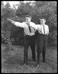 Dois meninos não identificados posam apontando pistolas, julho de 1915