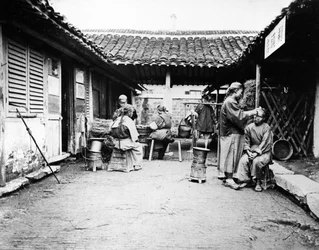 Barbeiros itinerantes em uma casa de campo, China, c.1875
