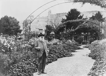 Claude Monet (1840-1926) em seu jardim em Giverny, 1925